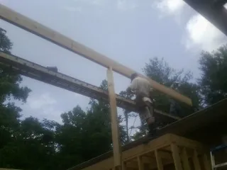 Carpenter setting a ridge beam over a new addition frame — Ice Dam Removal by Roofing Brothers in Tafton