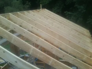 New roof rafters set over an addition before sheathing in Tafton