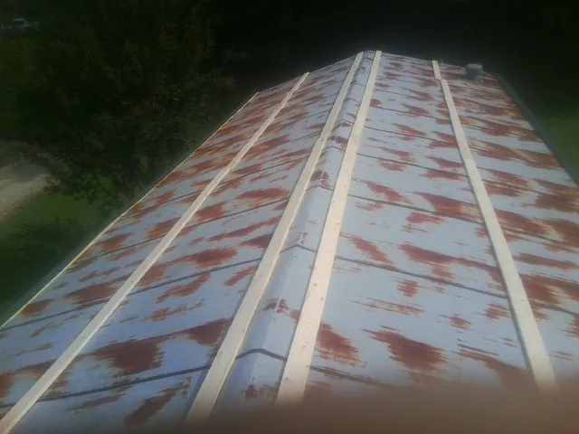 Rusted metal roof panels with new wood purlins before replacement — Storm Damage Roof Repair in Tafton by Roofing Brothers