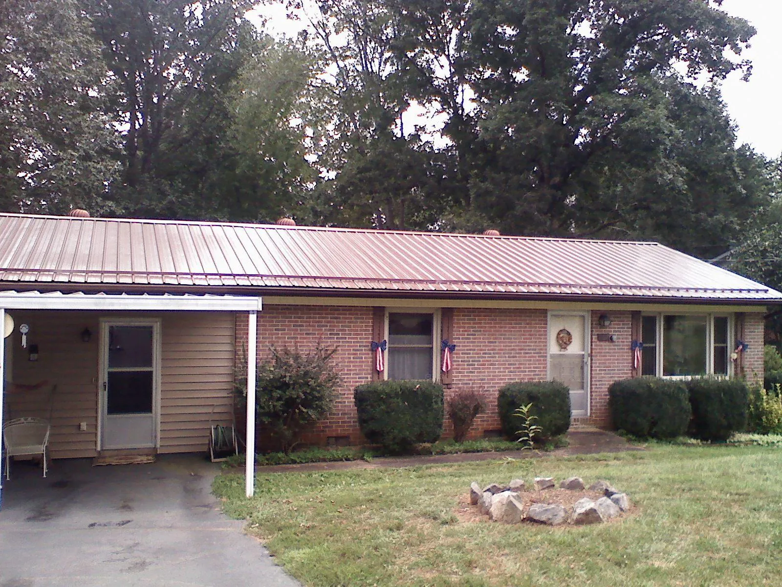 Bronze metal roof and carport on a brick ranch home — Roof Repair work by our crew in Tafton